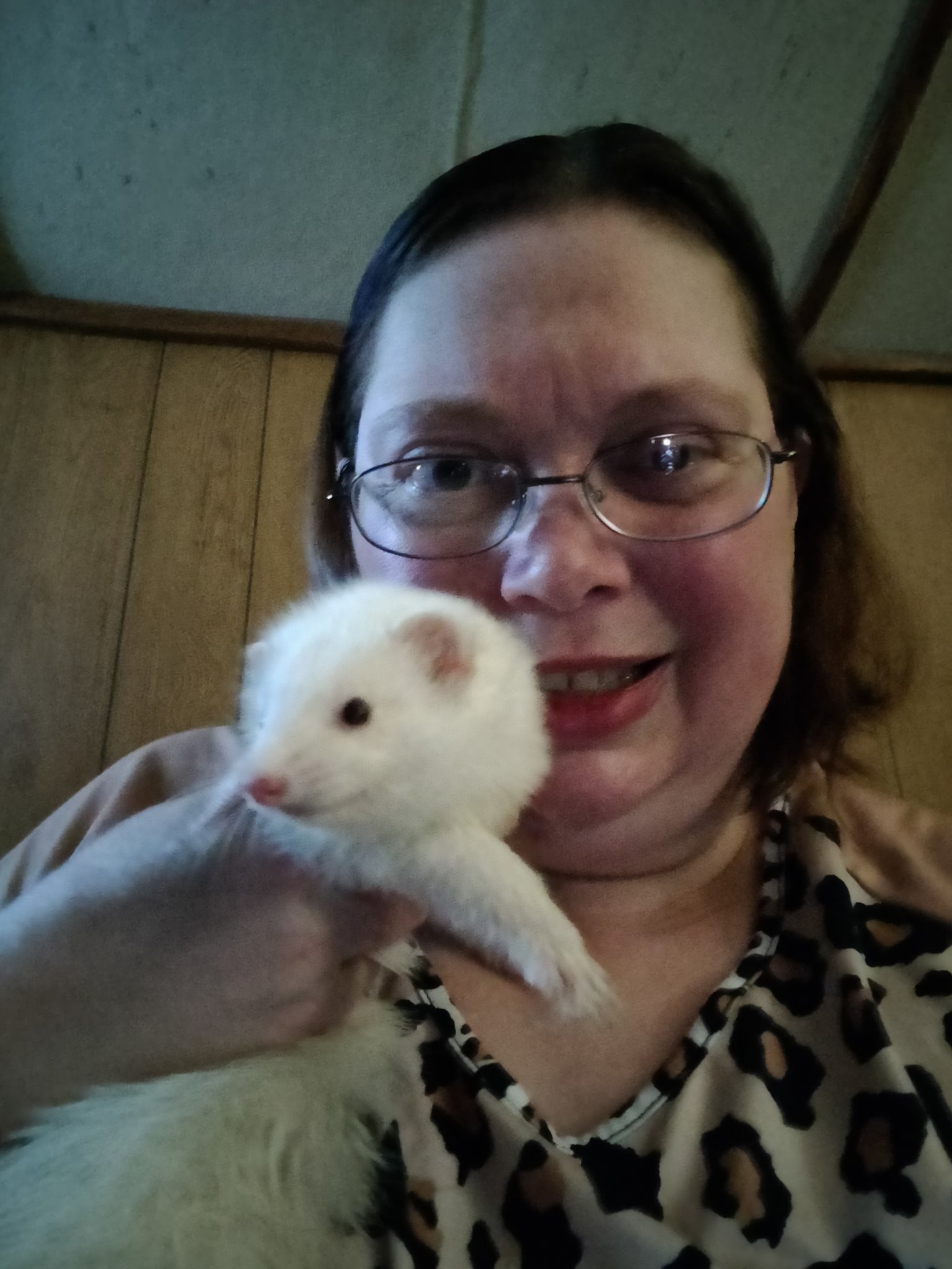 Shelly holding a rescue ferret close to her shoulder